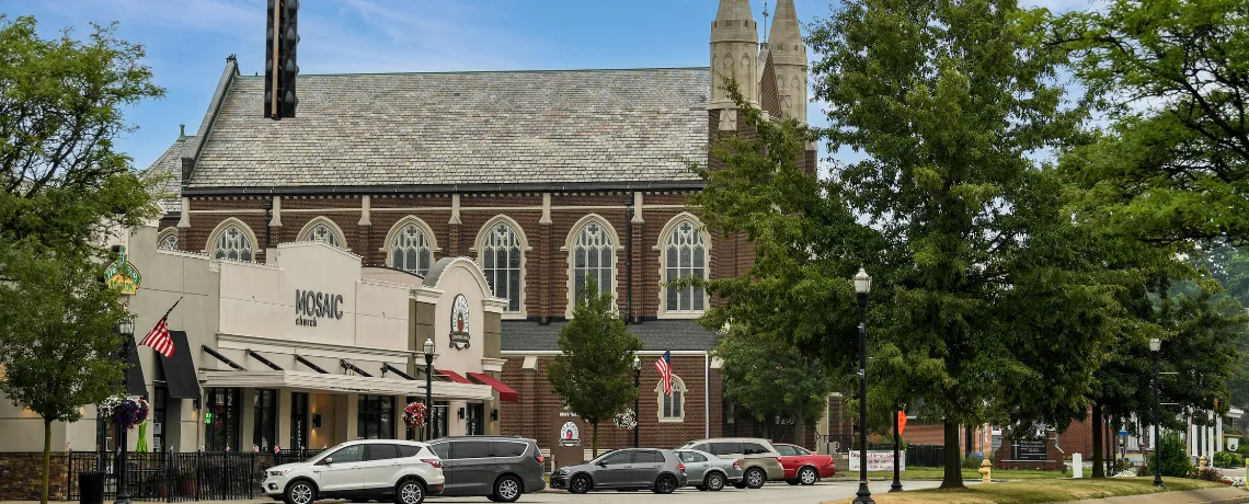A church and storefronts along a tree-lined downtown Wadsworth street